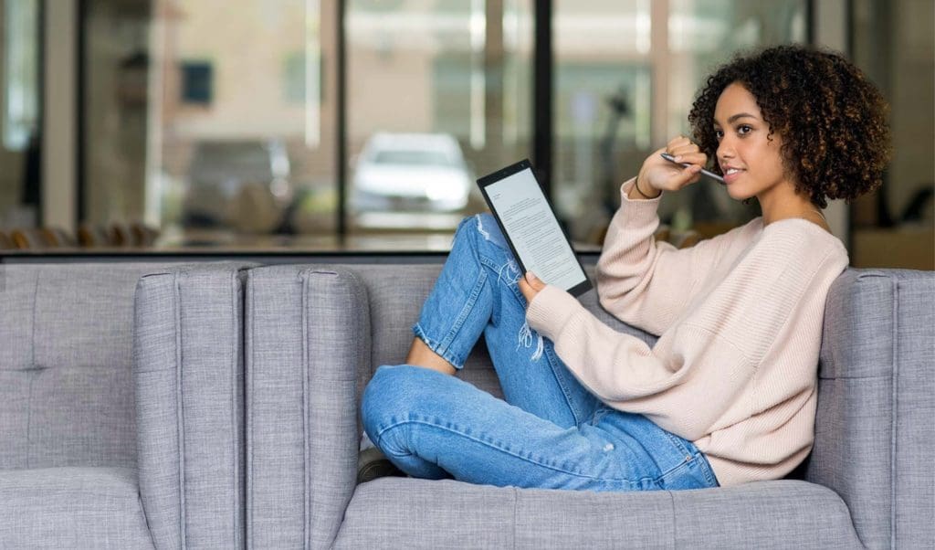sony-digital-paper-slider-03 Image of woman sitting on couch holding a Sony Digital Paper device